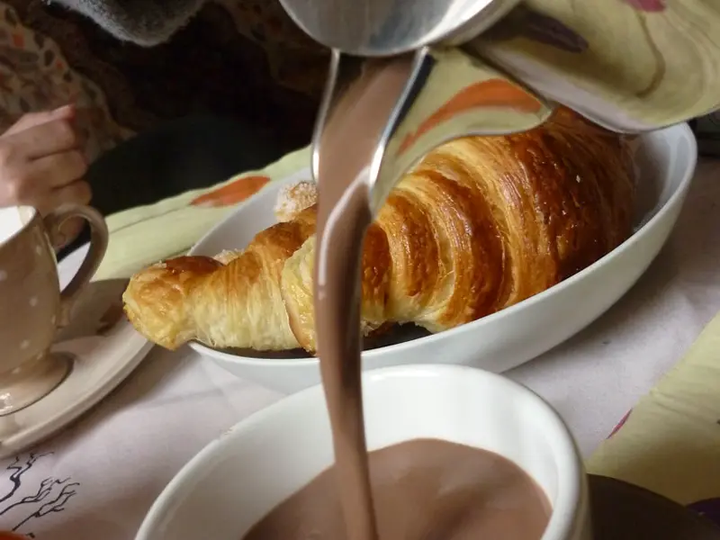 Chocolat chaud versé à côté d’un croissant (photo d’illustration)