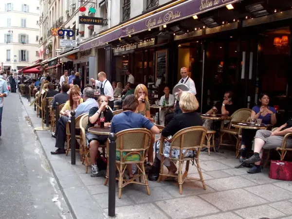 Terrasse de café dans une rue commerçante de Paris (photo d’illustration)